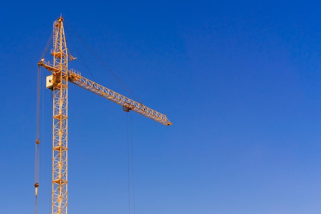 Grúa de construcción amarilla sobre un fondo de cielo azul