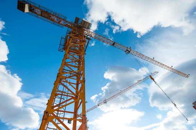 Foto grúa de construcción de elevación en el fondo de las nubes y el cielo azul