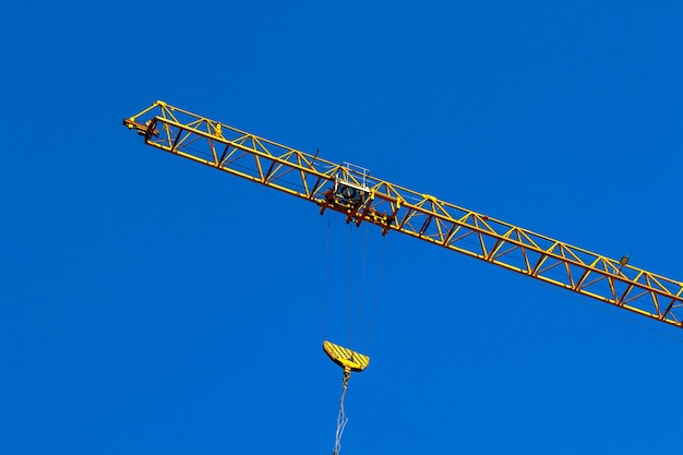 Foto grúa de construcción y gancho de grúa. concepto de operación y elevación de carga, fondo de cielo azul