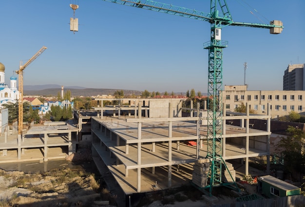 Grúa y construcción de obra contra el cielo azul