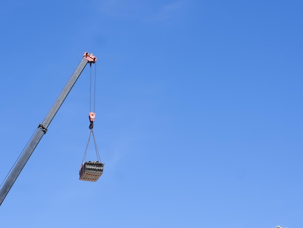 Grúa de construcción con pluma de grúa con una carga en altura