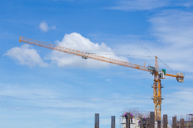 grúa de construcción y trabajador de la industria de la construcción con cielo azul