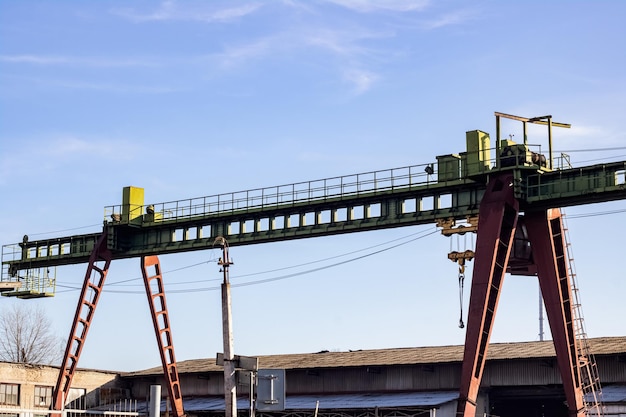 Grúa de contenedores de pórtico ferroviario sobre fondo blanco.