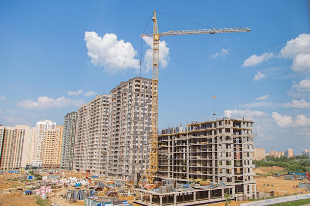 Grúa y edificio en construcción contra el cielo azul