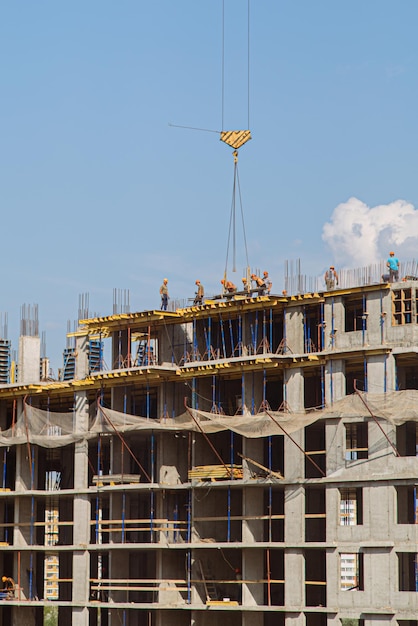 Grúa y edificio en construcción contra el cielo azul