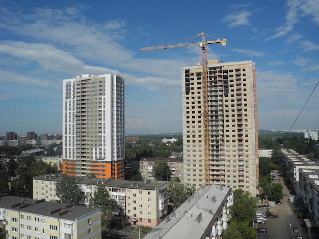 Foto grúa y edificio en construcción contra el cielo azul