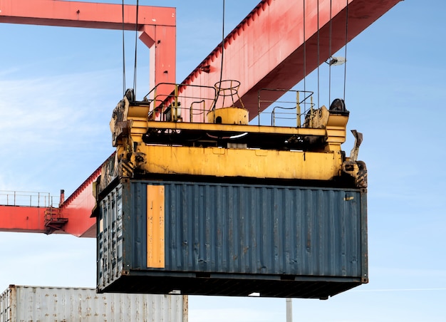 Foto la grúa está elevando contenedores en el muelle