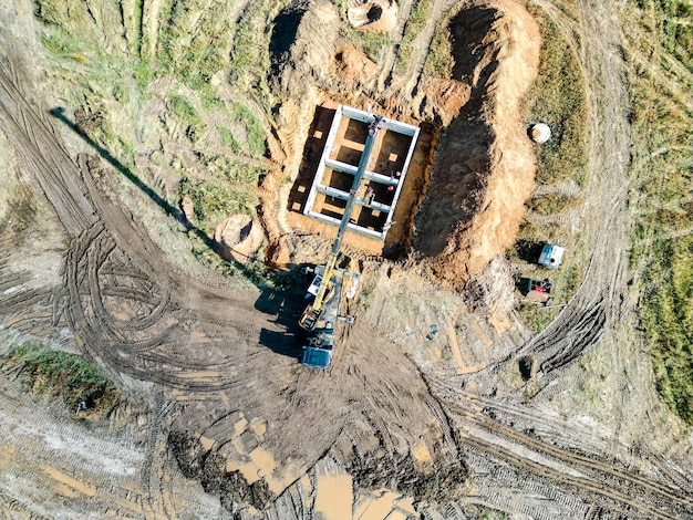 Grúa ensambla bloques de cimentación en el sitio de construcción Vista desde arriba Fotografía de drone Cimentación prefabricada de bloques de hormigón armado