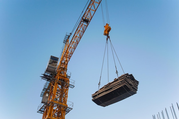 una grúa levanta una carga en una nueva casa en construcción