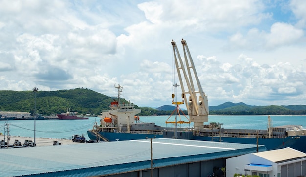 La grúa portuaria industrial levanta la carga de la caja de contenedores de exportación a bordo en el puerto de Tailandia