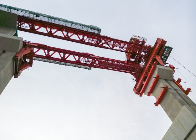 Foto grúa roja para la construcción del puente del tren.