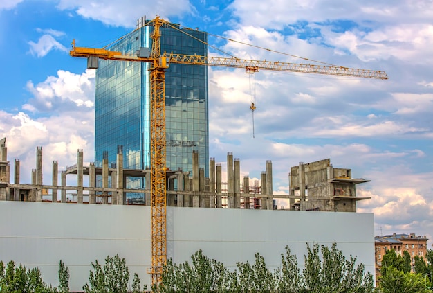 La grúa en un sitio de construcción en la ciudad cerca de un edificio de varios pisos