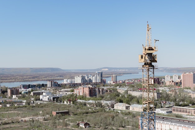 Grúa en el sitio de construcción panorama de la ciudad edificio sin terminar edificio en construcción panorama de la ciudad construcción de un edificio de gran altura rusia