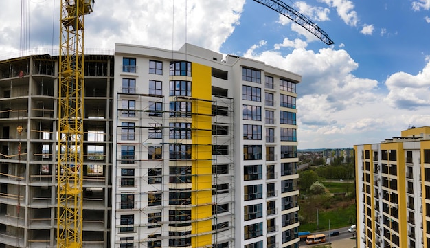 Grúa torre en edificio residencial de hormigón alto en construcción. Concepto de desarrollo inmobiliario.