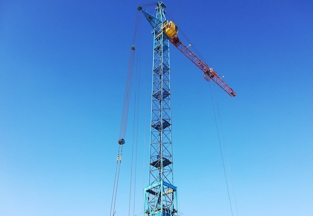 Grúa torre sobre un fondo de cielo azul.