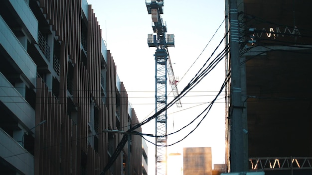 Grúa torre de trabajo colgando cables en el primer plano industrial