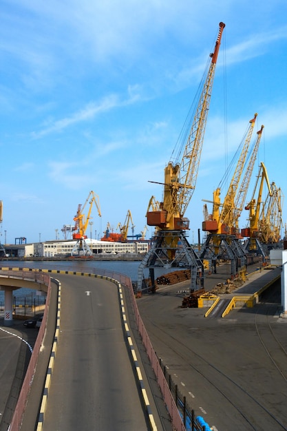 Grúas altas y grandes barcos amarrados en el puerto marítimo industrial