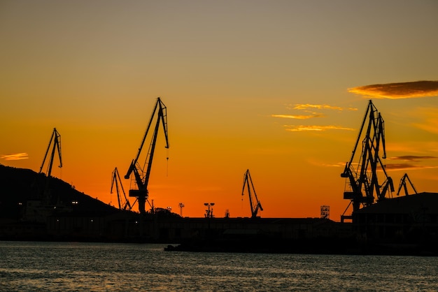 Grúas del astillero del puerto contra el cielo del atardecer en Ferrol Galicia España