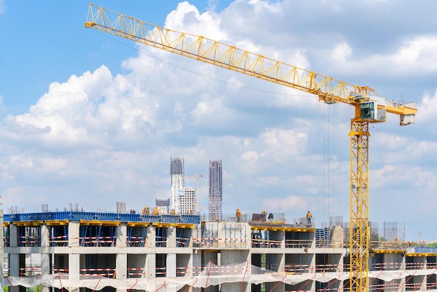 Grúas de construcción cerca de la fachada de una casa en construcción industria de la construcción moderna Venta y alquiler de bienes inmuebles