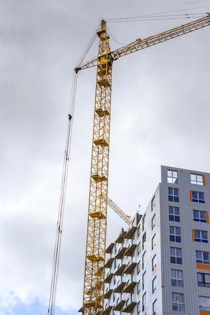 Grúas y construcción de edificios y las nubes. Composición vertical