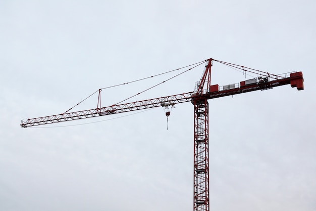 Grúas de la construcción de la torre en el cielo blanco