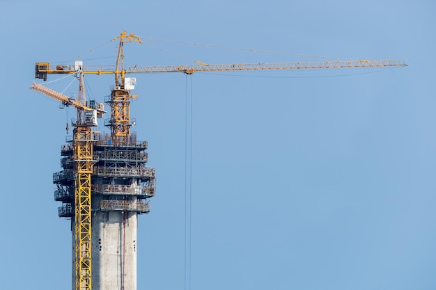 Grúas de construcción en la torre del puente de hormigón