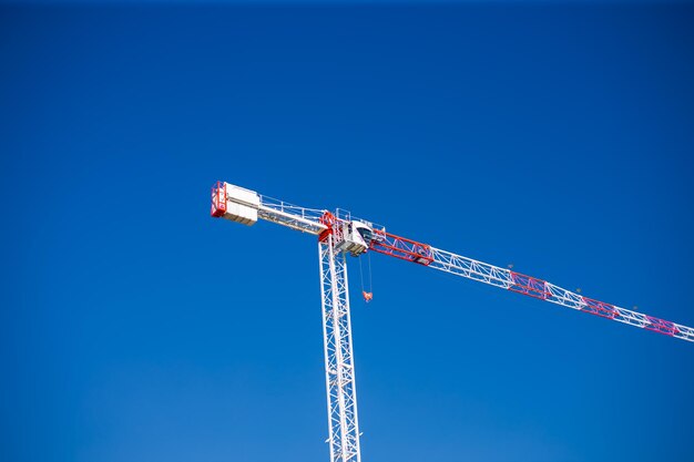 Foto las grúas de construcción trabajan en el sitio de creación contra el fondo del cielo azul vista inferior de la industria