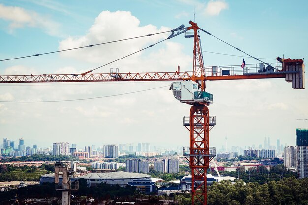 Grúas contra edificios en la ciudad contra el cielo