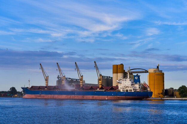 Grúas portuarias de la ciudad en el fondo del barco Descarga de mercancías para importación o exportación