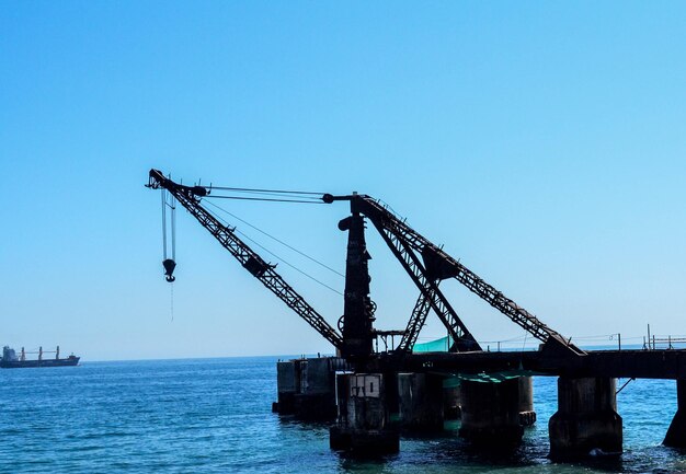 Foto grúas en el sitio de construcción contra un cielo azul despejado