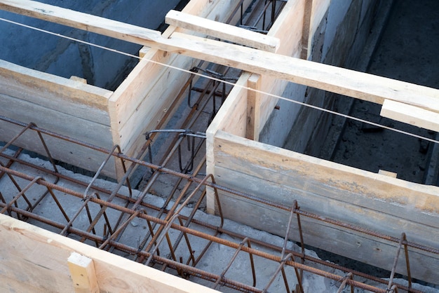 Gründungsort für neue Gebäudedetails und Verstärkungen mit Stahlstäben und Walzdraht in Holzdecks, die für das Zementgießen vorbereitet werden