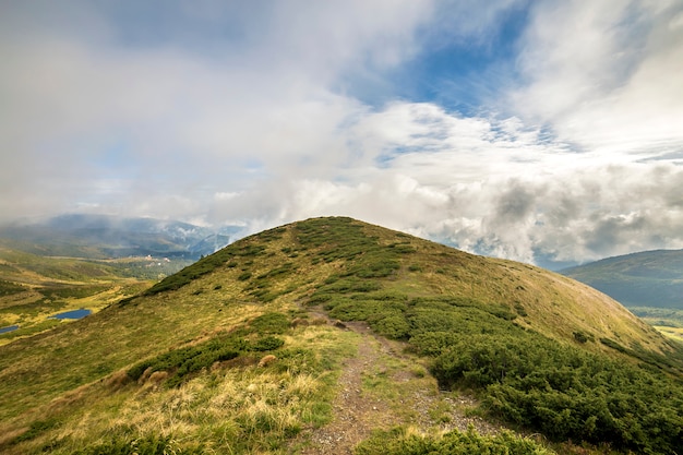 Grüne Berge auf blauem Himmel mit weißen Wolken