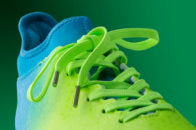 Grüne blaue Turnschuhe auf grünem Hintergrund. Fragment von Sportschuhen aus nächster Nähe.