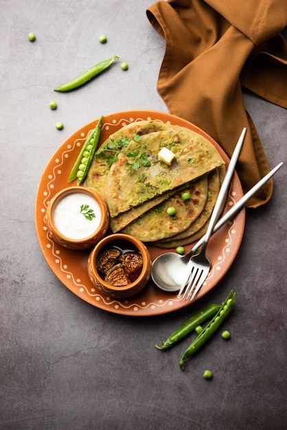 Grüne Erbsen oder Matar Ka Paratha ist ein Punjabi-Gericht, ein indisches ungesäuertes Fladenbrot aus Vollkornmehl, grünen Erbsen. Serviert mit Ketchup und Quark