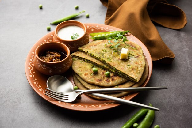 Grüne Erbsen oder Matar Ka Paratha ist ein Punjabi-Gericht, ein indisches ungesäuertes Fladenbrot aus Vollkornmehl, grünen Erbsen. Serviert mit Ketchup und Quark