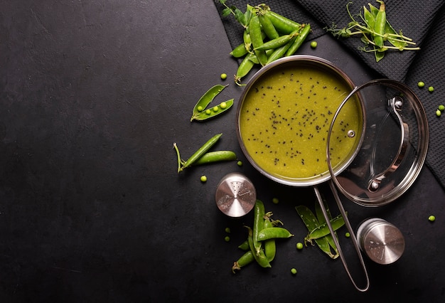 Grüne Erbsenpüreesuppe auf einem schwarzen Tisch