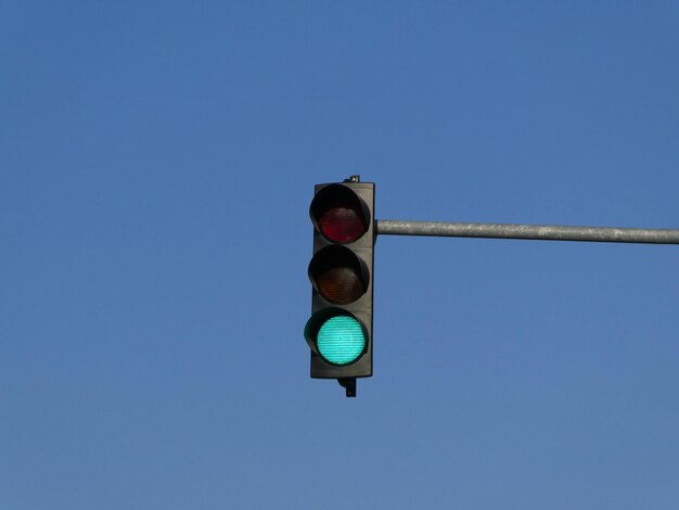 Grüne Farbe auf der Ampel mit blauem Himmel im Hintergrund