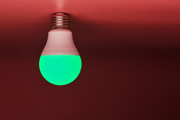 Grüne Glühlampe, moderne Energieeinsparung, Kopienraum. Minimales Ideenkonzept.