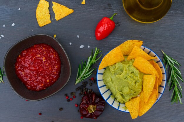 Grüne Guacamole-Soße mit knusprigen Maischips und Paprika-Salsa-Soße