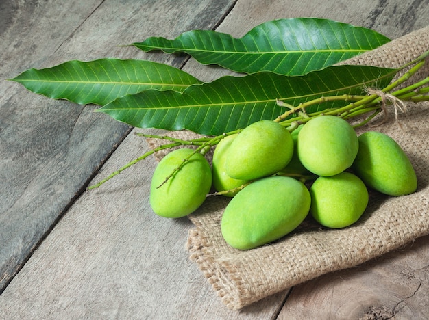 Grüne Mango auf Holzhintergrund. Thailändisches Lebensmittelkonzept.