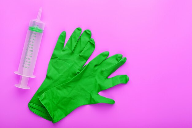 Grüne medizinische Spritze und Handschuhe