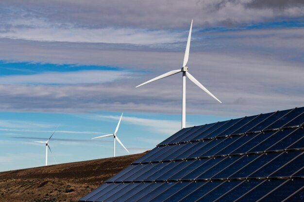 Grüne nachhaltige Energiewindmühlen-Stromgeneratoren mit Wolken und blauem Himmel