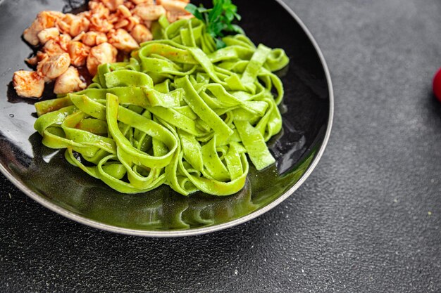 grüne Nudeln rote Tomatensauce Tagliatelle Hühnerfleisch Gemüse Essen Mahlzeit Snack auf dem Tisch