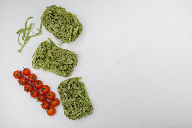 Grüne Pasta-Zutaten-Set, auf weißem Steintischhintergrund, Draufsicht flach, mit Kopienraum für Text