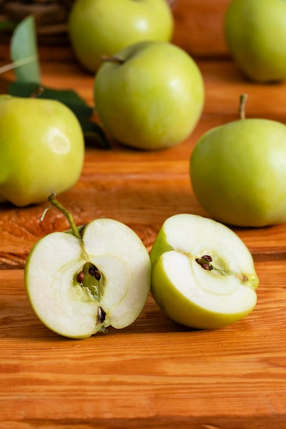 Grüne Äpfel auf einem hölzernen Hintergrund, selektiver Fokus auf Apfelhälften