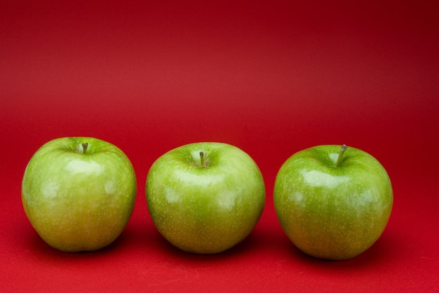 Grüne Äpfel auf einer roten Oberfläche