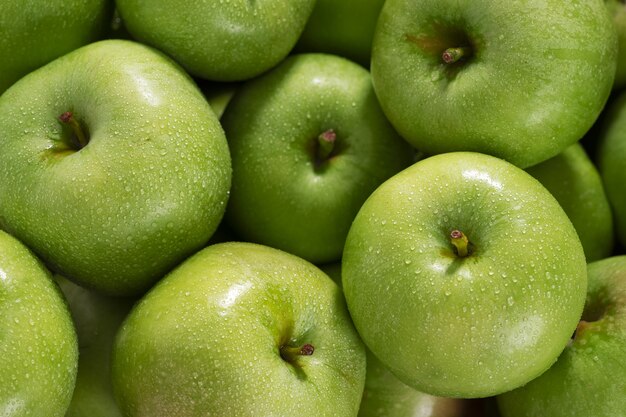 Grüne Äpfel mit Wassertropfen auf der Schalennahaufnahme.