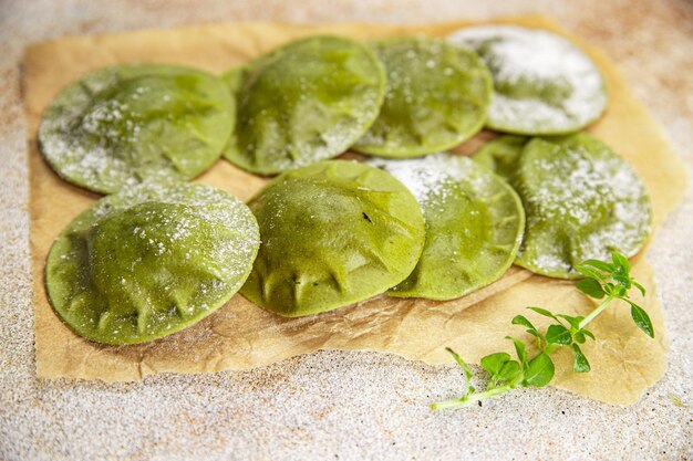 Foto grüne ravioli, grüner teig, spinat, basilikum, gemüse, gesunde mahlzeit, snack auf dem tisch