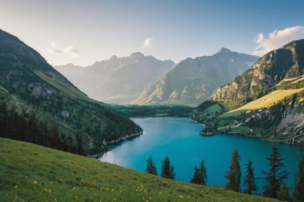 Foto grüne seen und wälder am fuße der schneebedeckten berge unter dem goldenen sonnenschein