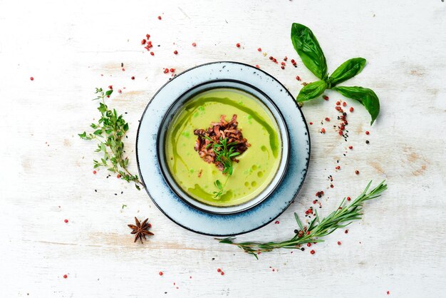 Grüne Suppe mit Speck. Suppe mit Brokkoli, Spinat und grünen Erbsen. Ansicht von oben. Rustikaler Stil.